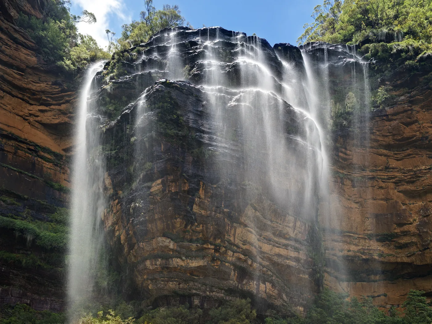 A waterfall dropping into the forested valleys of the Blue Mountains